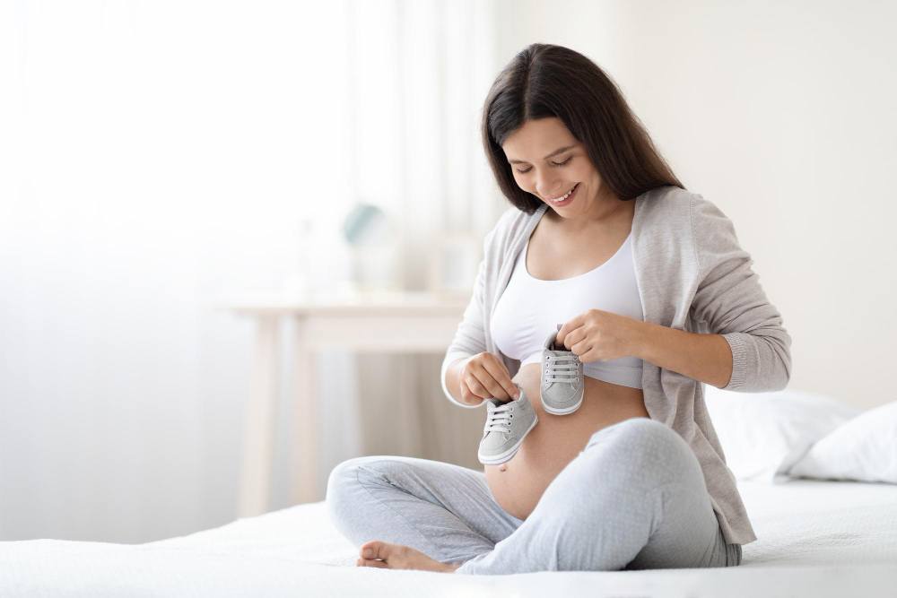 pretty-pregnant-woman-holding-baby-shoes-her-big-belly